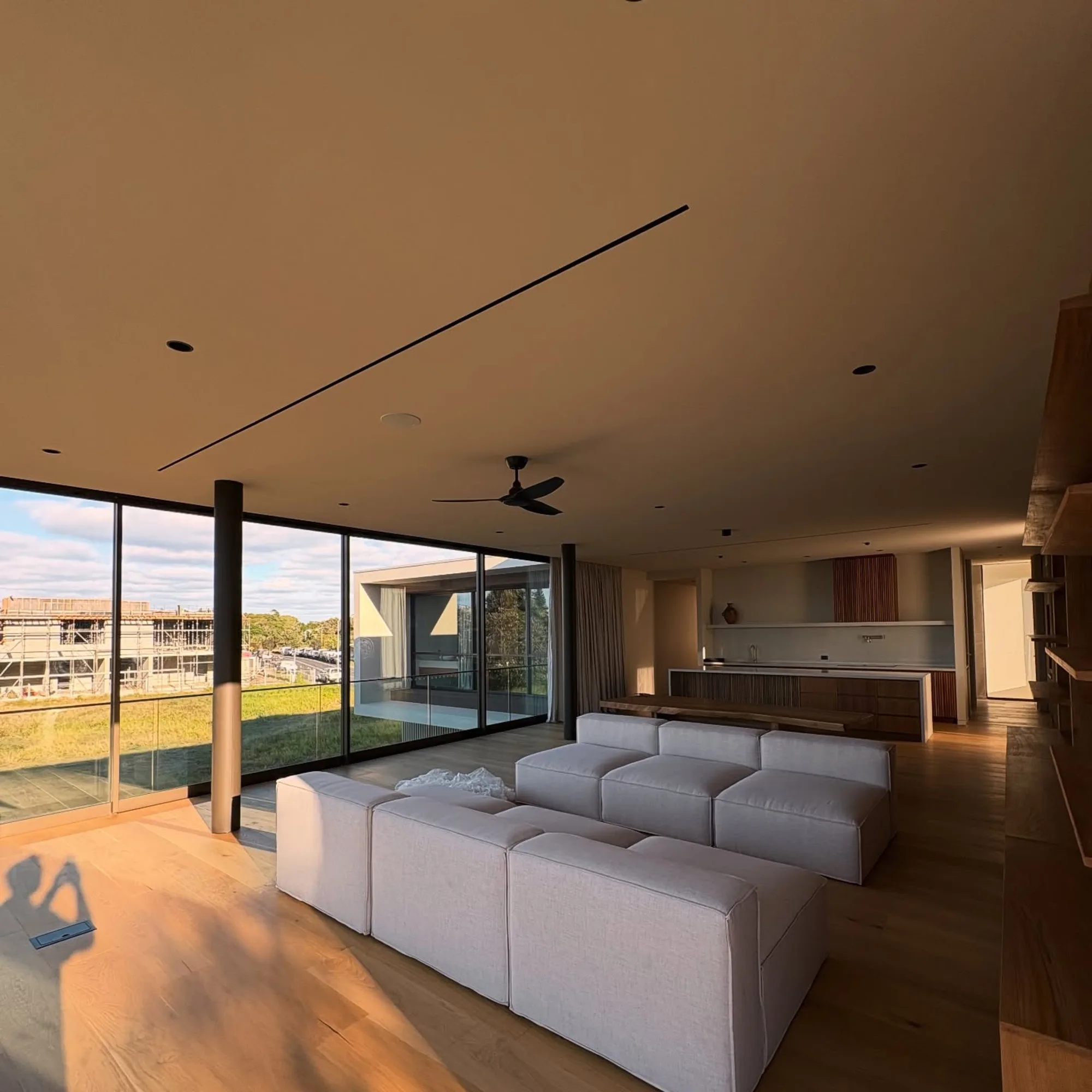 Living room at dusk with a slot diffuser set flush into the ceiling